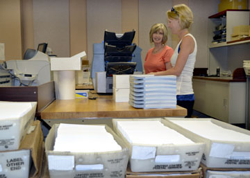 Sharon and Nikki, Midwest Energy Finance Department employees in Hays, prepare 13,675 capital credit checks for mailing to former Midwest Energy members. Credits paid out this year were earned in 1990-1991, and many members have changed addresses since then.