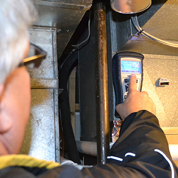 Brian Dreiling, Midwest Energy’s Manager of Energy Services, uses a combustion analyzer to measure the efficiency of a new furnace installed in a home in Hays.