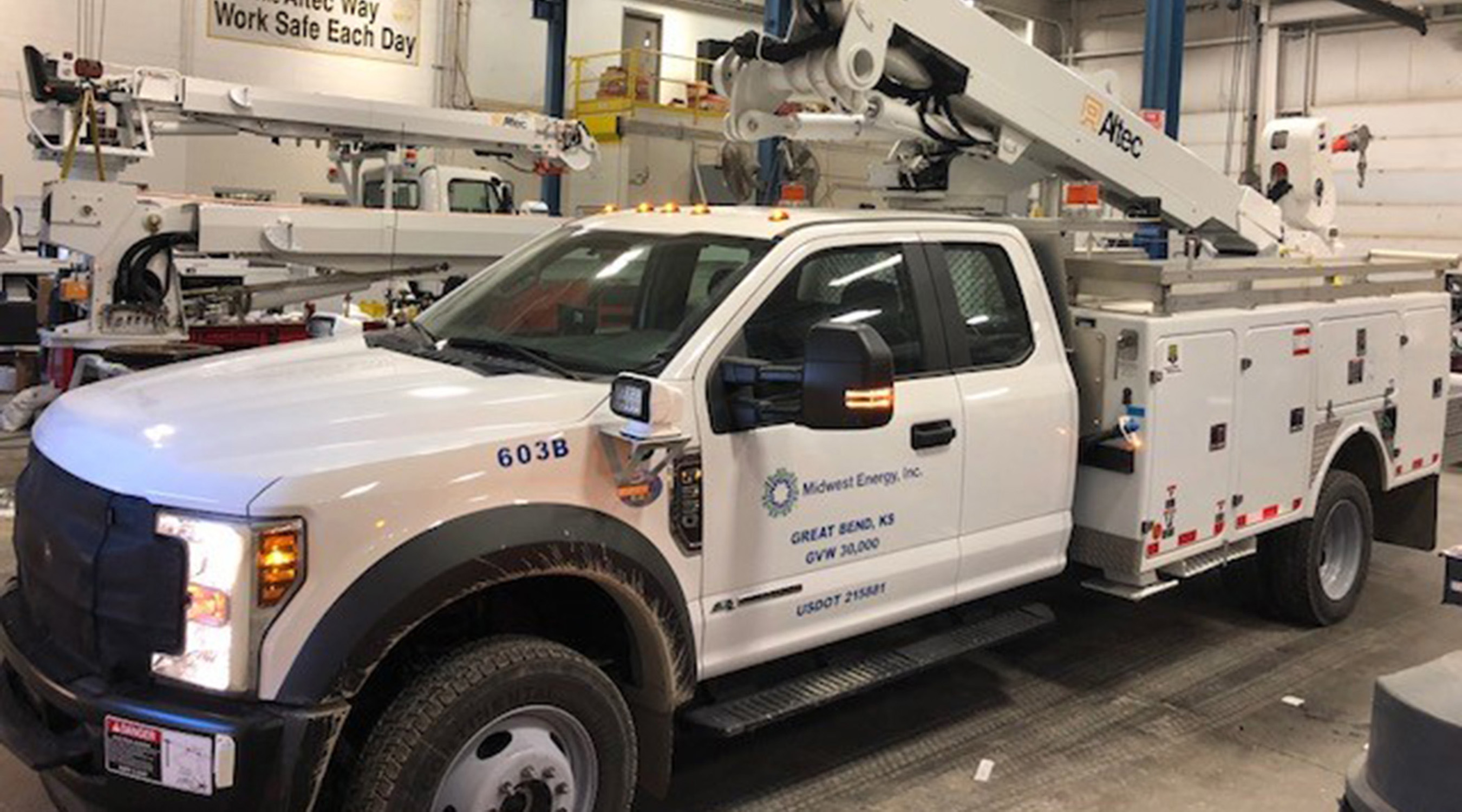 A photo of a Midwest Energy service bucket truck inside of a garage.