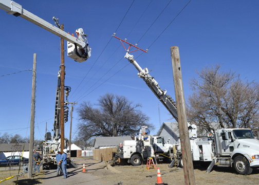 Midwest Energy line crews from Oakley, Colby and Sharon Springs combine to replace poles behind a church at Center and 4th in Oakley. Since 2006, Midwest Energy has replaced more than 800 poles and 300 transformers to improve reliability for customers in the city.