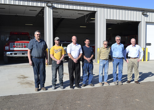 Representatives from the Quinter Volunteer Fire Department, QMC Construction and Midwest Energy pose in front of the department's new station in Nov. 2012.