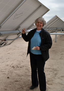 Donna Cooper of Hays signs panels in her row; Cooper, a retired high school science teacher, has been a proponent of renewable energy for decades.