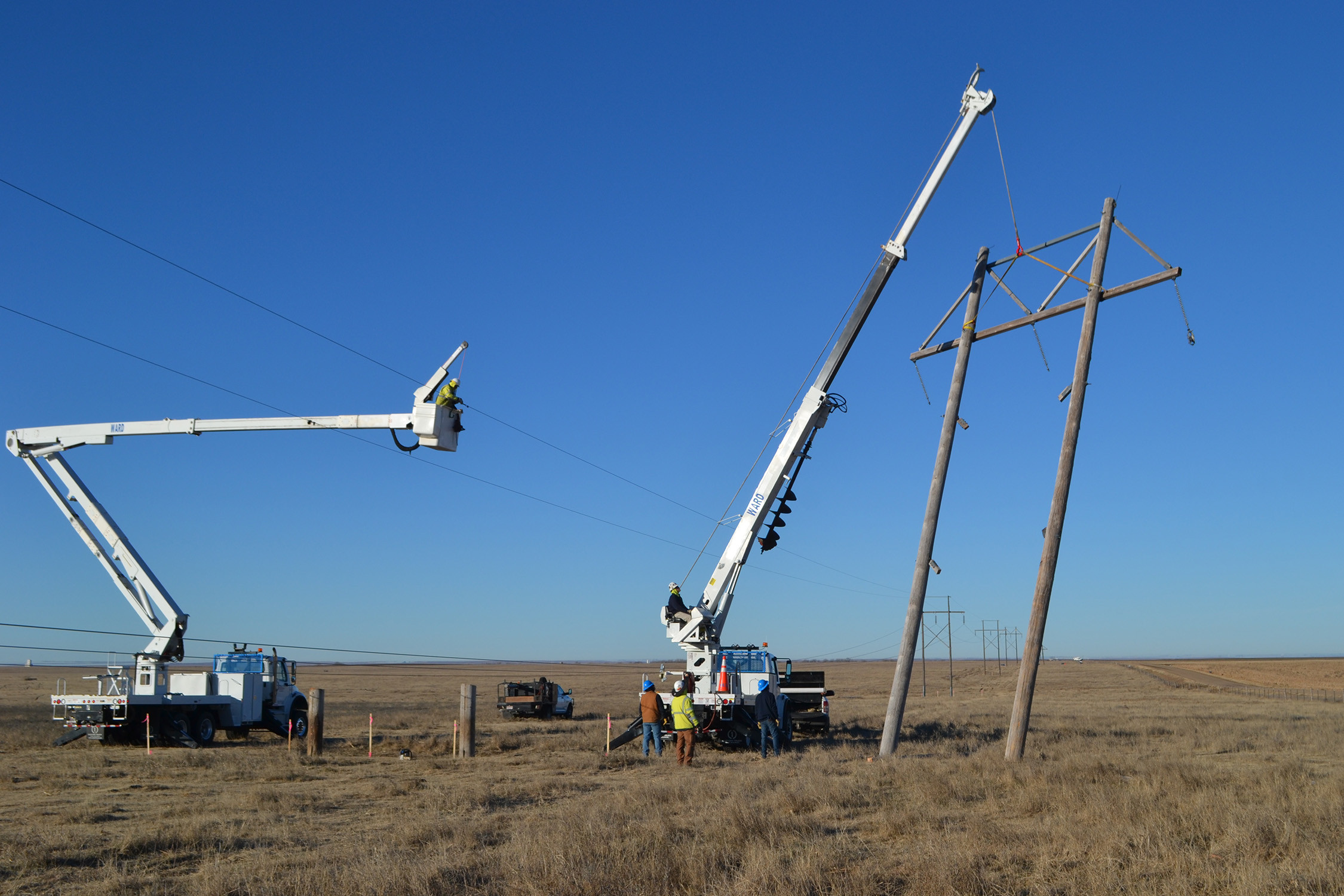 An electric crew works to remove an H-frame transmission structure
