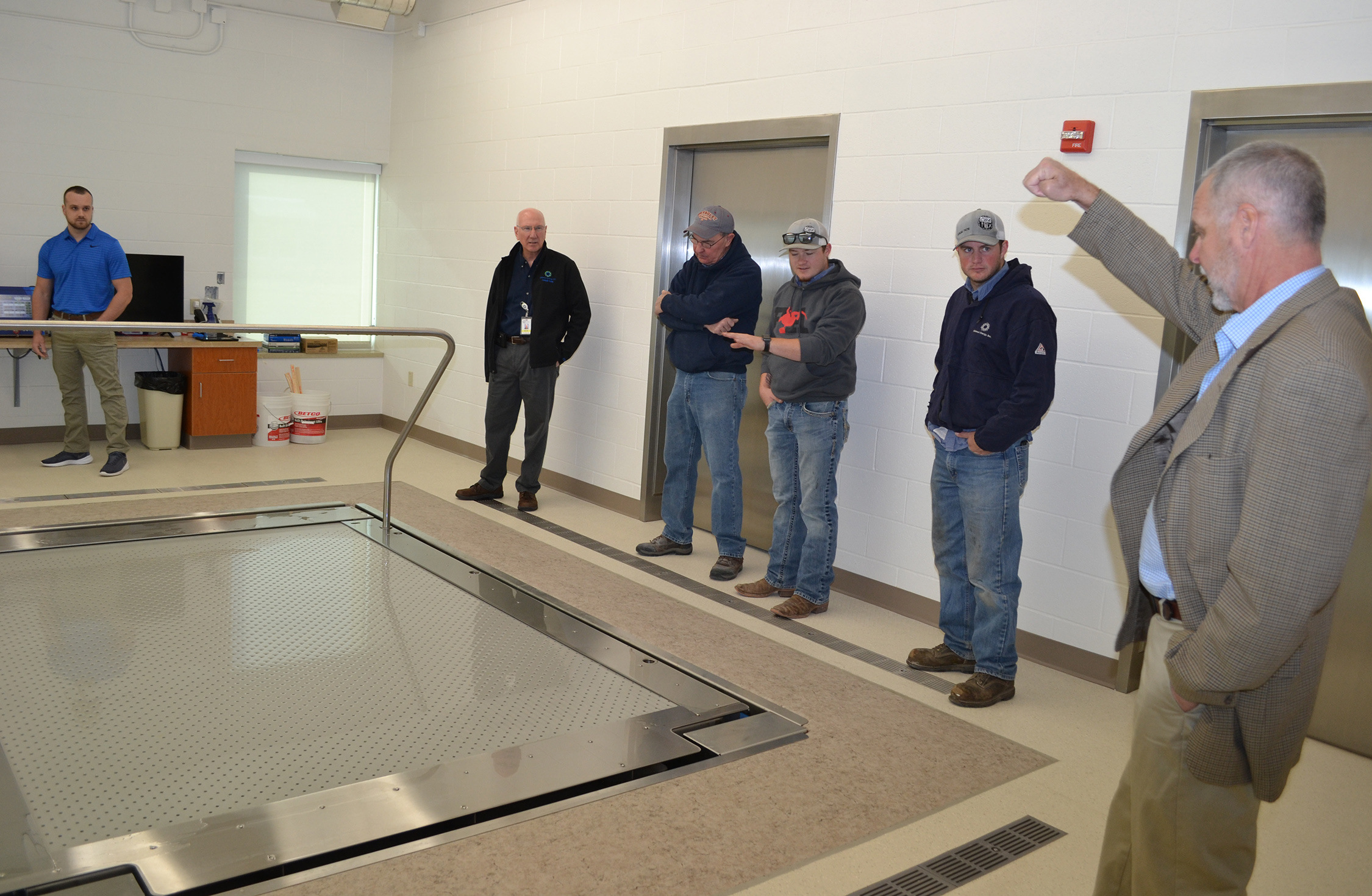Five men look at a zero-entry physical therapy pool at the Rooks County Health Center in Plainville, Kansas, while one man explains its operation.