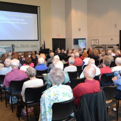 More than 120 Midwest Energy members sit in chairs as they view a PowerPoint presentation displayed on a wall to the left.  The 2015 Annual meeting was held in the Robbins Center on the Fort Hays State University Campus in Hays, Kan.