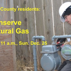 A gas technician working on a meter, with a message to conserve gas through 11 am on Sunday, Dec. 25.