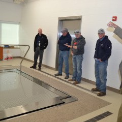 Five men look at a zero-entry physical therapy pool at the Rooks County Health Center in Plainville, Kansas, while one man explains its operation.