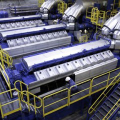 A technician is dwarfed by a Wärtsilä natural-gas powered internal combustion engine at Midwest Energy’s Goodman Energy Center in Hays, Kan. Midwest Energy is beginning a $30 million expansion of the facility in 2015, which will add three new engines and 27 megawatts of generating capacity to the facility.