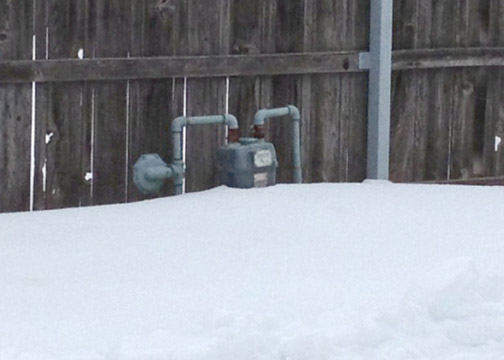 A meter remains buried in an alley in Hays after 17 inches of snow fell Feb. 20-21; slow-melting deep snow has prevented readers from accessing thousands of meters.